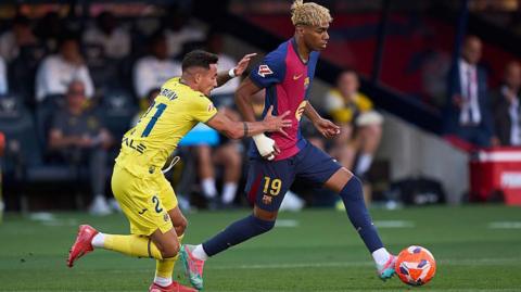 Lamine Yamal of FC Barcelona competes for the ball with Yeremy Pino of Villarreal CF