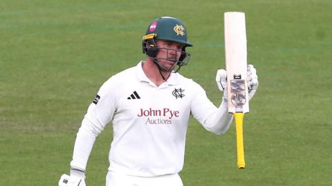 Liam Patterson-White raises his bat for reaching 50