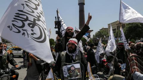 Supporters of the Taliban, some carrying guns and the white flag, celebrate the third anniversary of the group's takeover of Afghanistan.