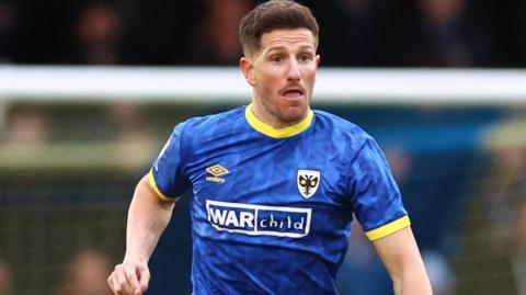 Sam Hutchinson in action for AFC Wimbledon