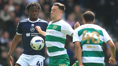 Queens Park Rangers' Harvey Vale (centre) and Millwall's Derek Mazou-Sacko (left) battle for the ball 