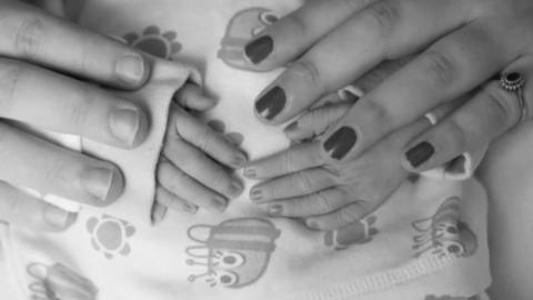 Parents' hands with baby