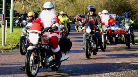 Motorcyclists travelling to the hospital, some dressed in Father Christmas costumes and loaded with gifts