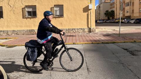 A man rides a bicycle through the streets of southern Spain