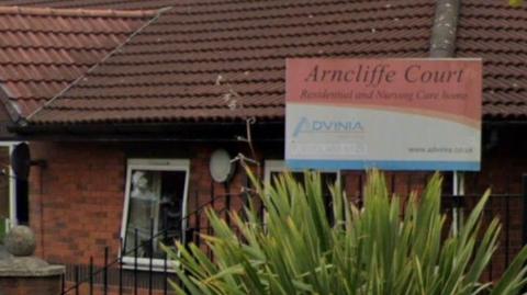 Exterior of care with outside sign.