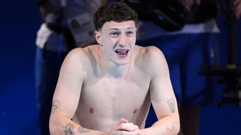 Diver Noah Williams crouching down by the side of the pool at the Paris 2024 Olympics