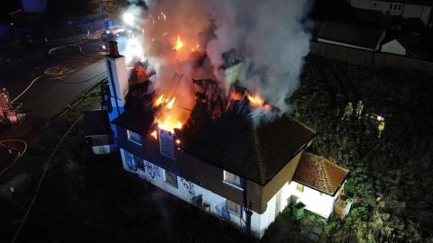 The roof of a derelict house on fire