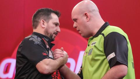 Jonny Clayton (L) is congratulated by Michael van Gerwen