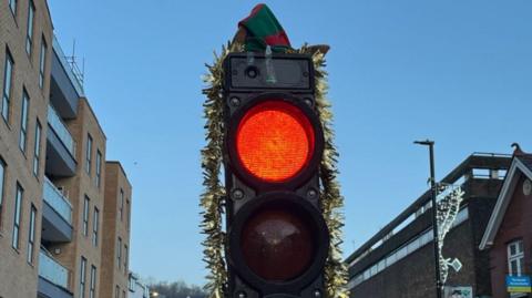 Traffic lights in Caterham decorated with tinsel and a hat