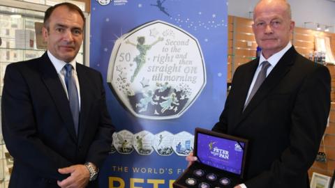 Treasury Minister Alfred Cannan MHK and Bill Henderson MLC with a commemorative set of the coins