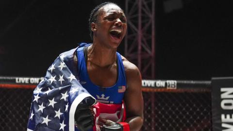 Claressa Shields celebrates a win with the American flag over her shoulder