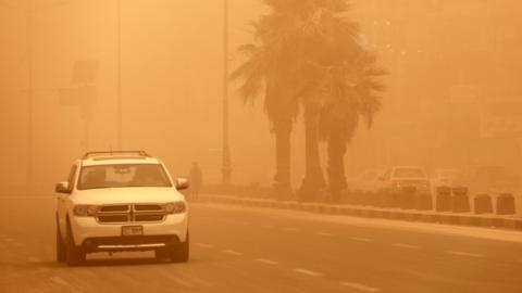 A car is driven along a street in Baghdad, Iraq, during a dust storm (5 May 2022)