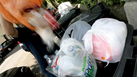 Man empties waste into a bin
