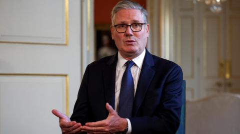 Keir Starmer wearing a dark suit and blue tie