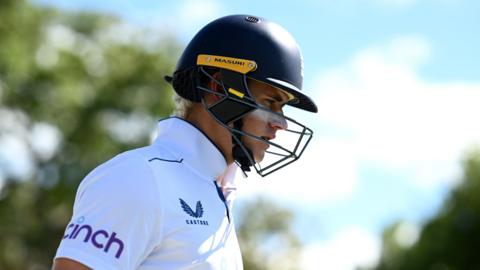 England's Jacob Bethell walks out to bat