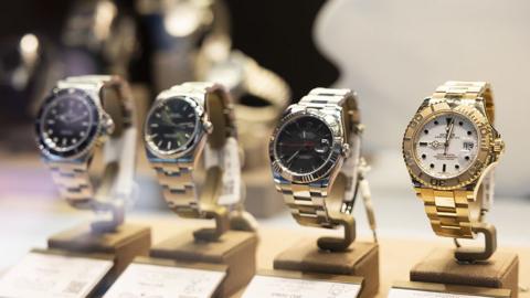 A row of four Rolex watches on display 