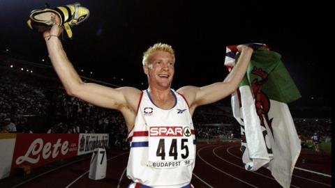 Iwan Thomas on the running track at an event in Budapest wearing his team GB jersey.