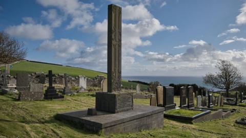 The gravestone for author Hall Caine in Maughold Churchyard