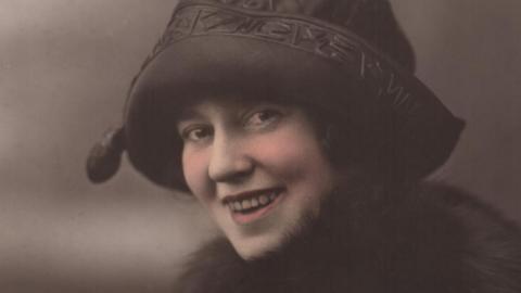 An archive photograph of a woman wearing a hat and scarf 