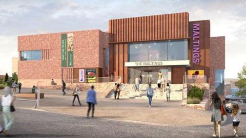 A computer generated image of how The Maltings, an arts venue in Berwick, might look once it's rebuilt. It's a brown building made up of two cubed sections with lots of windows above the entrance. People are walking towards it.