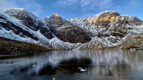 Snow-covered hills overlooking frozen Lochan a'Choire at Creag Meagaidh near Spean Bridge.