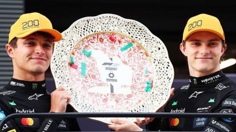 Lando Norris and Oscar Piastri holding the constructors' trophy