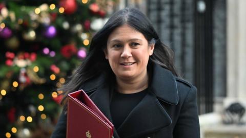 Culture Secretary Lisa Nandy carrying a red ministerial folder embossed with the Crown, wearing a winter coat, in Downing Street