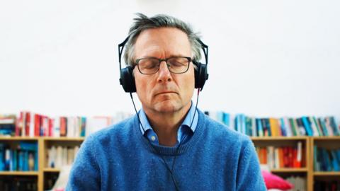 Michael Mosley meditating with headphones on