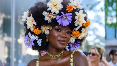 Woman with flowers in her hair and gold jewellery at New York fashion week