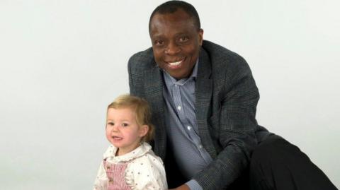 Fleur sitting with Ikenna Omeje in a studio shot