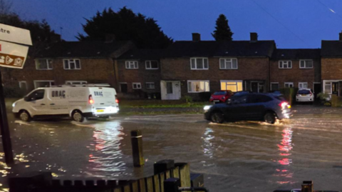 A van and a car driving through flood water along Abingdon Road 