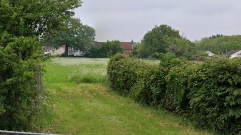 Land near Palmers Street in Walsham-le-Willows near Bury St Edmunds. It is a field with some overgrown foliage and bushes,.