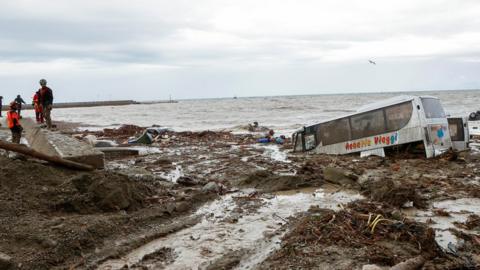 A bus and damaged cars are seen after being dragged into the Tyrrhenian Sea