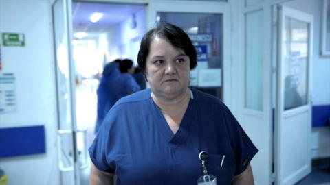 Surgeon Dr Oana Goidescu on shift at Buzău Hospital in blue scrubs. She has mid length black hair