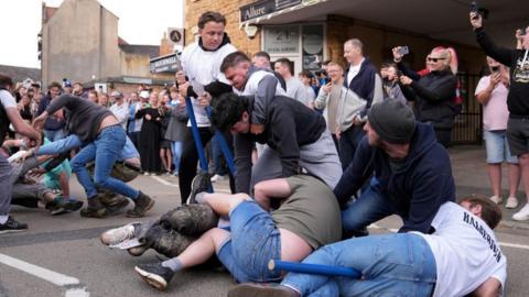 A group of men attempt to disarm the halberdiers of their halberds after the reading of the charter, which was granted by King John in 1204 to the people of the town to allow them to hold a market and a fair, as part of the Rowell Fair Proclamation Day.