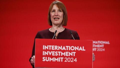 Chancellor Rachel Reeves standing at a lectern giving speech at International Investment Summit on Monday