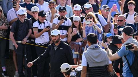 Scottie Scheffler walking past spectators during the 2025 Open Championship at Royal Portrush