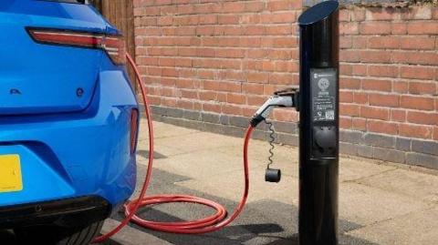 A blue electric car being charged at a point.