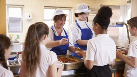 Pupils being served dinner