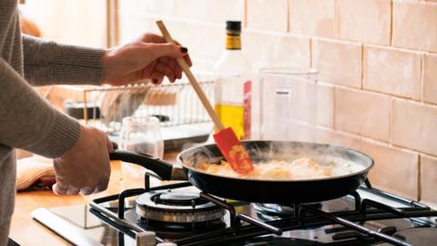 Person using gas hob