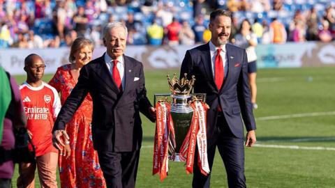 Josh and Stan Kroenke walk trophy out onto pitch