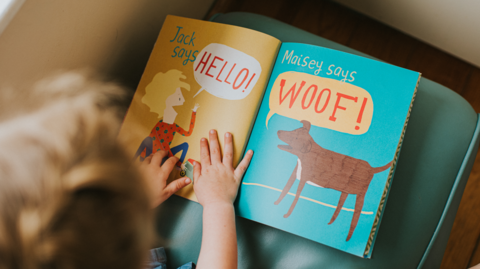 A child reading from a book at a nursery school