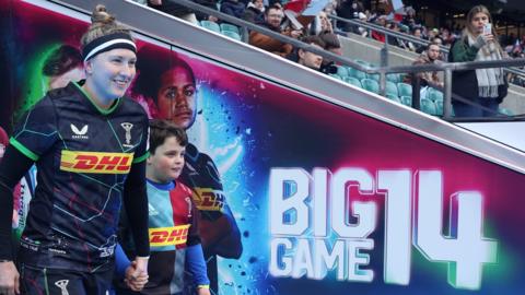 Emily Scott of Harlequins leads out her team during the Women's Allianz Premier 15s match between Harlequins and Exeter Chiefs at Twickenham Stadium in March 2023