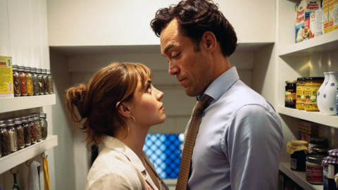 Bella Maclean and Alex Hassell face each other in cupboard