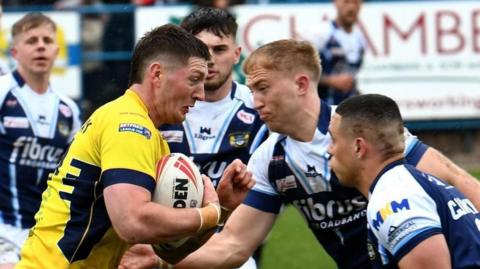 Whitehaven (in yellow) taking on Workington in navy blue and white on Good Friday