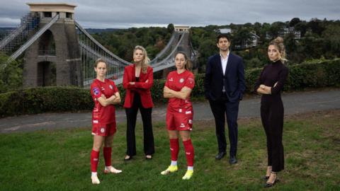 (Left to right) Emily Syme, Bristol City Women, Hannah Haynes, Mercury13 chief strategy officer, Vicky Losada, Bristol City Women captain, Mario Malave and Victoire Cogevina Reynal, Mercury13Founder's and co-CEOs all standing in front of the Clifton Suspension Bridge 