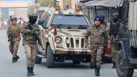 Four members of India's security forces wearing military fatigues arrive outside a police station in Srinagar, Indian Kashmir on 15 November 2025. 