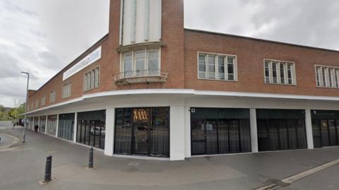 A bar on a street corner with a gold neon sign saying 'Vaal & Vaal'.