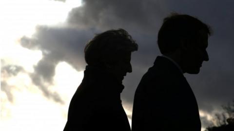 Silhouettes of Theresa May and Emmanuel Macron