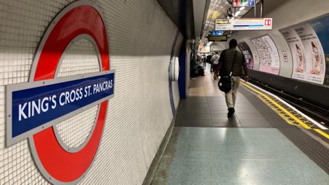 King's Cross platform shows passengers, Tube roundel
